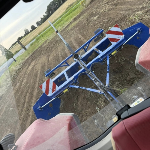 Traktor i gang med afretning af jord på en mark i forbindelse med et anlægsprojekt