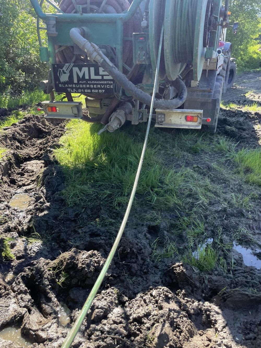 Kloakspulingsmaskine på mudret vej, hvor der udføres spuling af kloaksystem